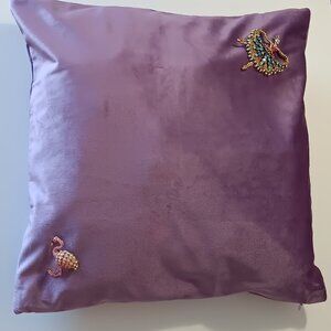 Flamingo and ballet brooches on a purple velvet style pillow cover.